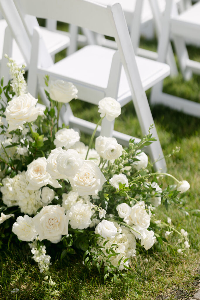 Garden-style aisle floral arrangements with white blooms and lush greenery at a Jewish wedding ceremony at River Bottoms Ranch in Midway Utah