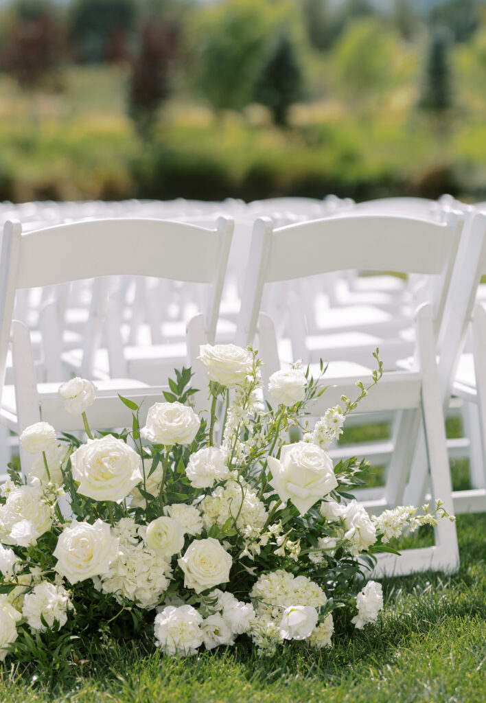 Luxury Jewish wedding ceremony aisle flowers with lush greenery and white blooms at River Bottoms Ranch in Utah