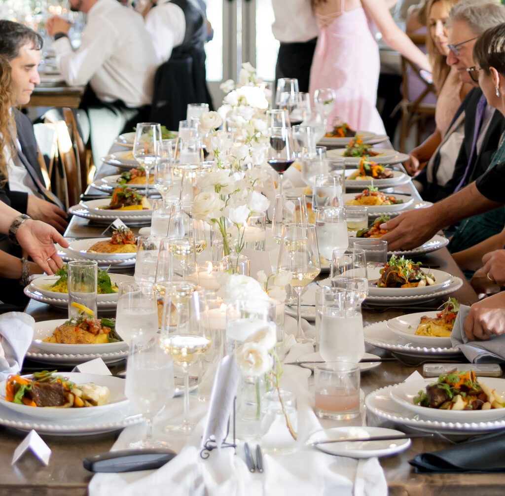 White wedding florals on farmhouse tables with modern bud vases, floating candles, and black accents at River Bottoms Ranch wedding in Midway Utah for a reception