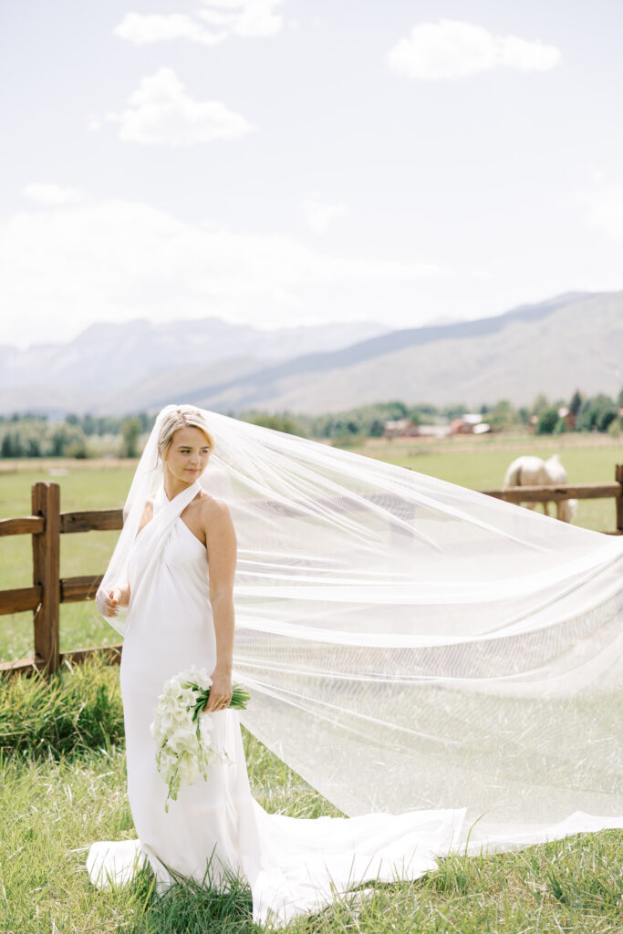 Luxury wedding bouquet with cascading white orchids and calla lilies against mountain wedding backdrop in Utah