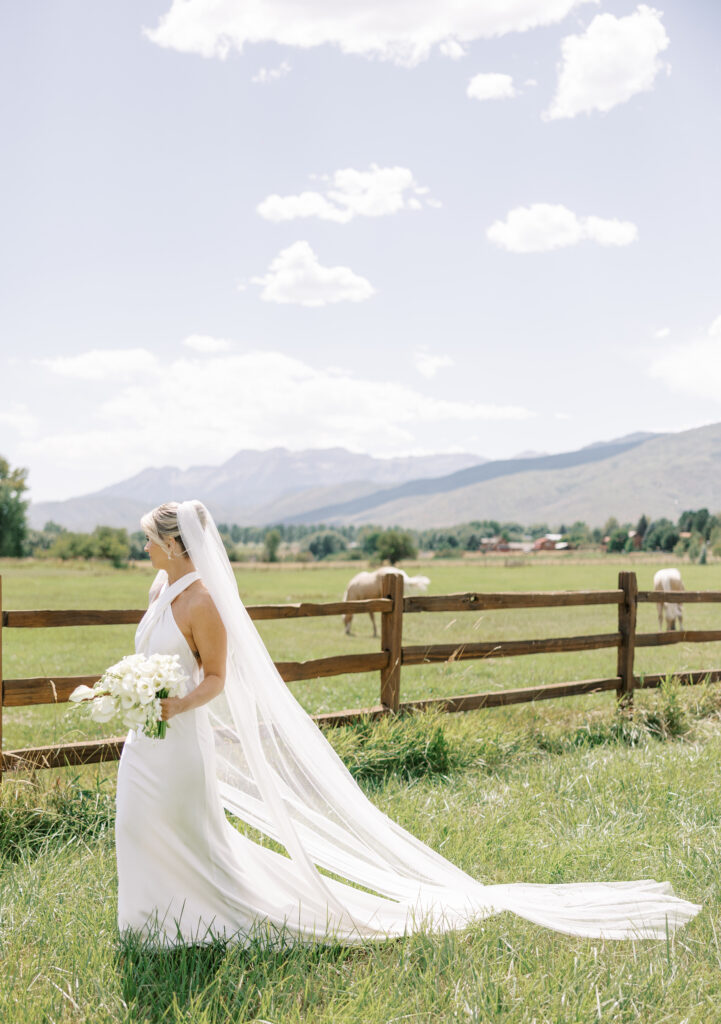 Luxury wedding bouquet with cascading white orchids and calla lilies against mountain wedding backdrop in Utah